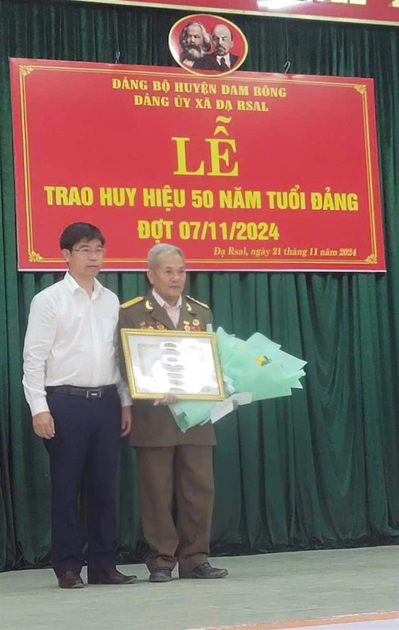 Đồng chí Nguyễn Văn Châu – Bí Thư huyện ủy trao tặng Huy hiệu 50 năm tuổi Đảng cho đồng chí Nguyễn Tiến Queng