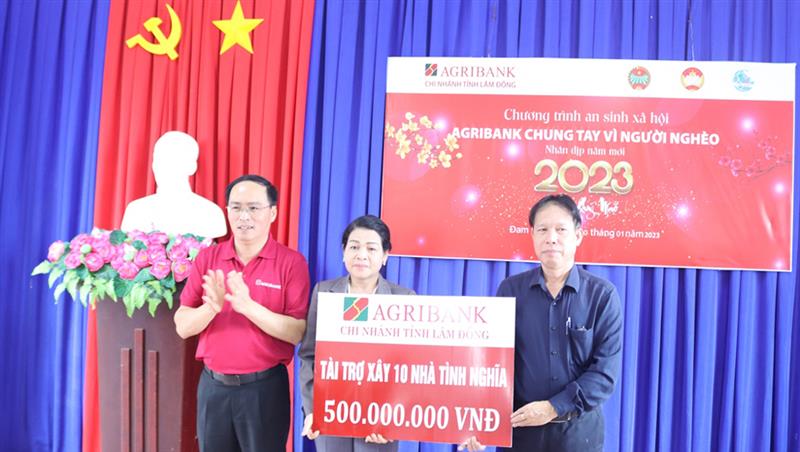 Đại diện lãnh đạo Agribank Lâm Đồng trao biểu trưng 500 triệu đồng tài trợ xây dựng 10 căn nhà tình nghĩa cho hộ nghèo, hộ khó khăn về nhà ở