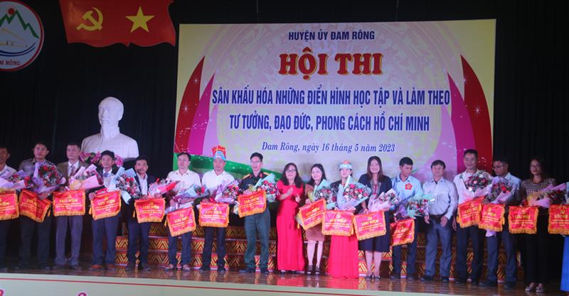 Đồng chí  Đa Cắt K' Hương - Phó Bí thư Thường trực Huyện ủy trao cờ lưu niệm cho các đội thi