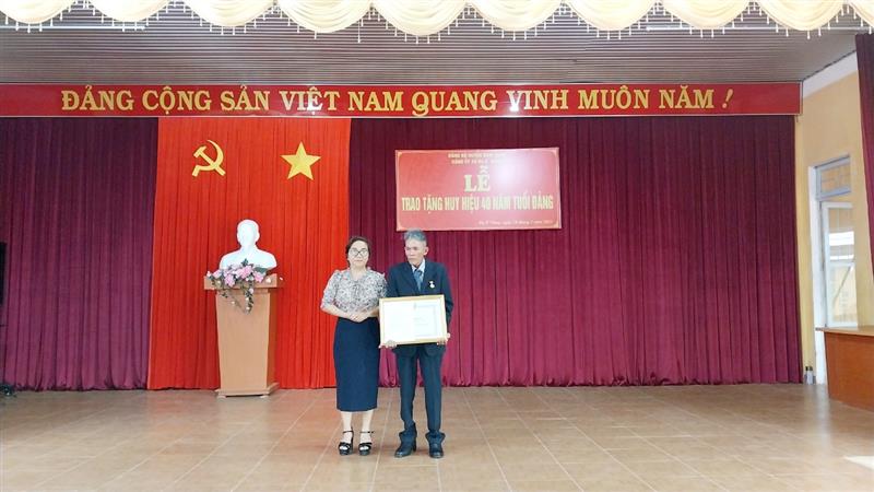 Đồng chí Đa Cắt K' Hương trao Huy hiệu 40 năm tuổi Đảng cho đồng chí Nguyễn Thế An