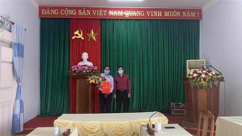Đồng chí Nguyễn Văn Lộc - Tỉnh ủy viên, Bí thư Huyện ủy, Chủ tịch HĐND huyện tặng hoa, trao quyết định cho đồng chí Trương Văn Sáng.