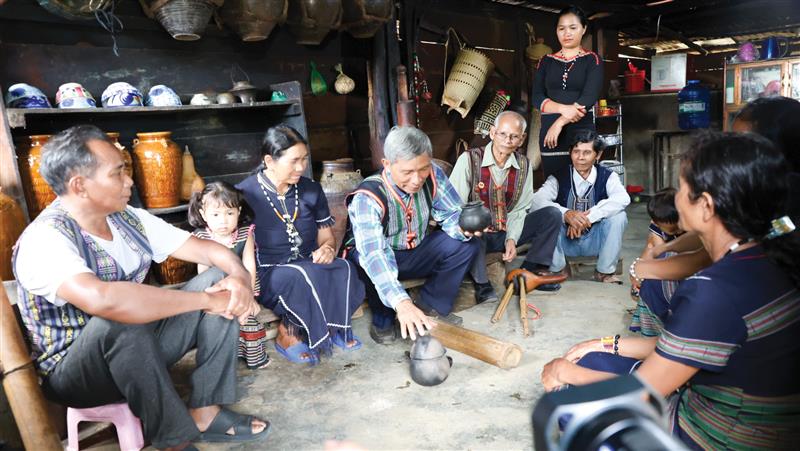 Già Ya Cát Tư (giữa) giới thiệu các di sản truyền thống của dân tộc M’Nông cùng bà con Nhân dân thôn Đạ Nhinh.jpg