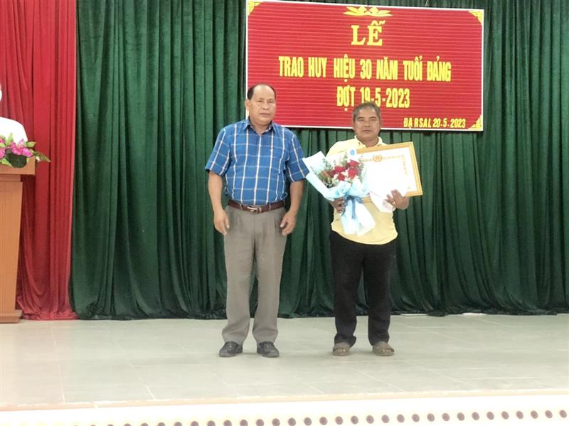 Đồng chí Liêng Hót Ha Hai - UVBTVHU, Phó CT UBND huyện trao Huy hiệu 30 năm tuổi Đảng cho đồng chí Bon Krong Y Brong