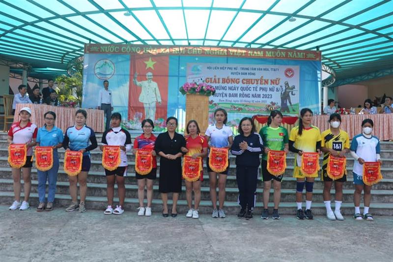 Đồng chí Phó Bí thư Thường trực Huyện ủy trao cờ lưu niệm cho các đội bóng chuyền tham gia giải